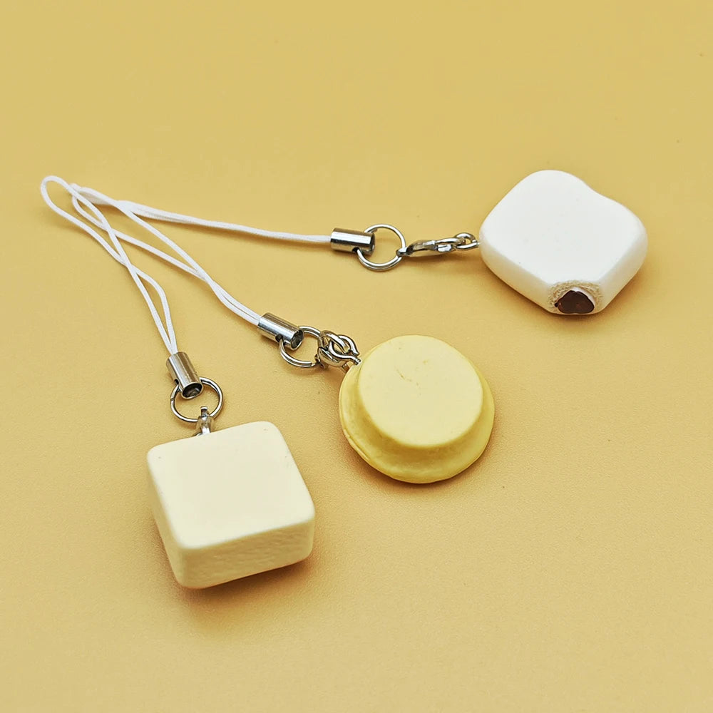BARESY smartphone cat accessories three cream and yellow phone charms with white straps on beige background