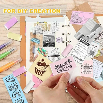 Hands peeling cupcake sticker on a scrapbook with pastel pens and color mini printer sticker paper for DIY creation