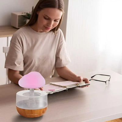 BARESY USB mini humidifier essential oil diffuser with pink mushroom top and wood grain base on desk with woman reading at table