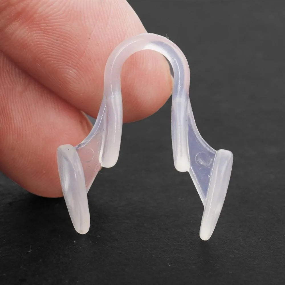BARESY clear silicone nasal clip anti-snoring device held between fingers to widen nostrils for better breathing
