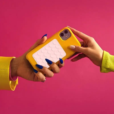 BARESY anti-slip silicone phone holder white textured pad on yellow phone case held between two hands