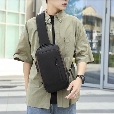 BARESY men's waterproof crossbody bag with USB port black sling worn by man outdoors with zip pockets