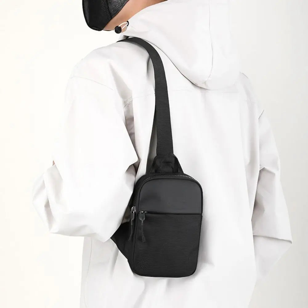 BARESY black minimalist trendy chest bag for men worn crossbody with adjustable strap on white jacket