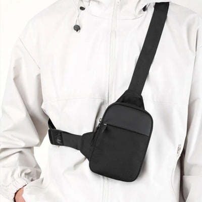 BARESY black nylon sling worn crossbody on a white jacket trendy chest bag for men with adjustable strap and zip pocket